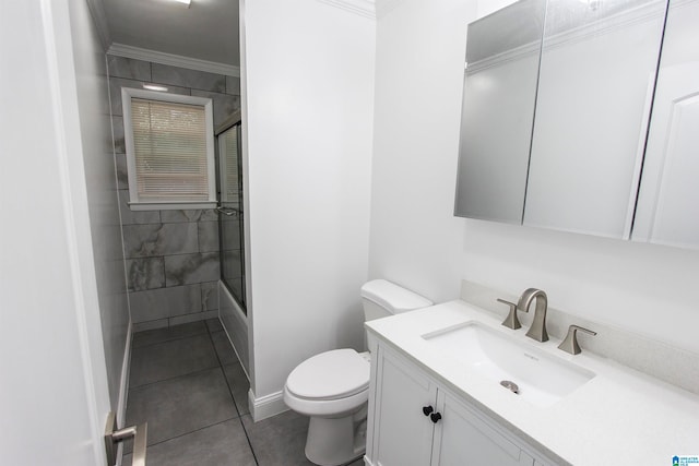 full bathroom featuring tile patterned floors, ornamental molding, bath / shower combo with glass door, vanity, and toilet