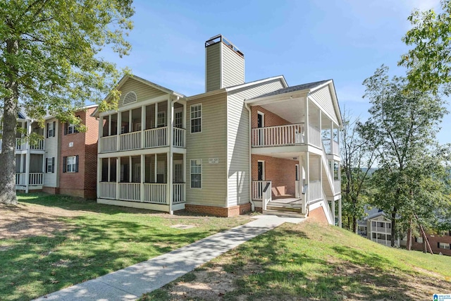 rear view of property with a yard and a balcony