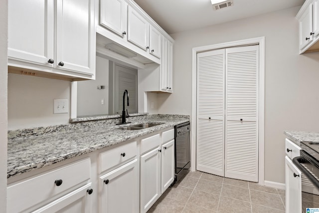 kitchen featuring white cabinetry, sink, light tile patterned floors, and dishwasher