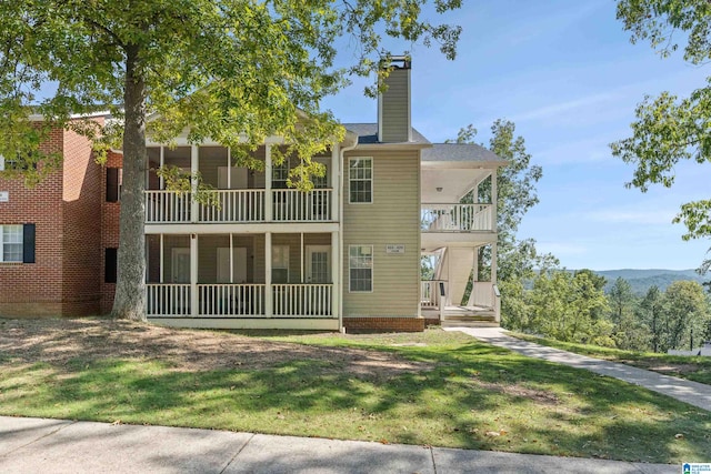 back of house featuring a yard and a balcony