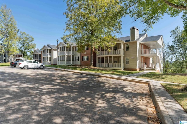 view of front of home with a front lawn and a balcony