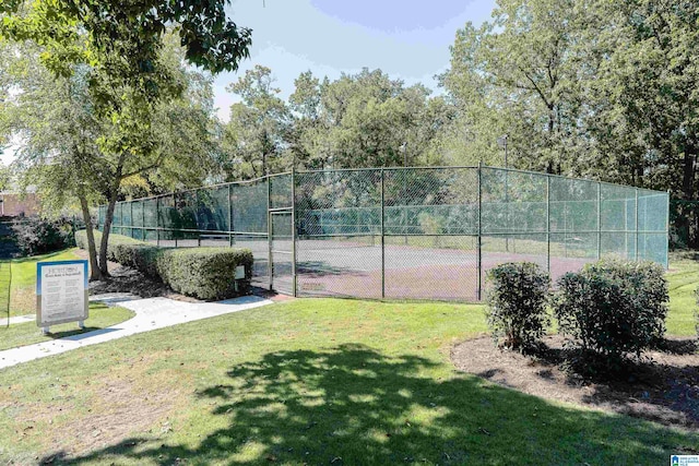 view of tennis court with a lawn