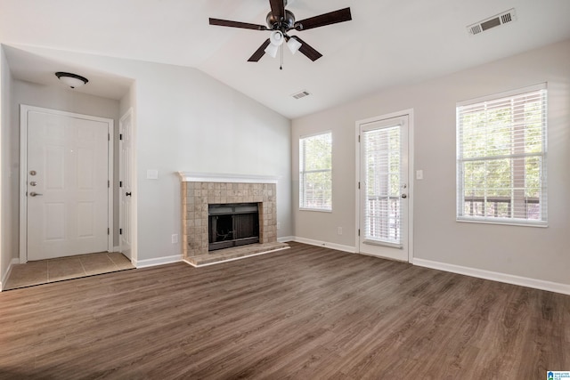 unfurnished living room with dark wood-type flooring, vaulted ceiling, and a wealth of natural light