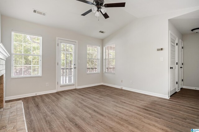 unfurnished living room featuring a fireplace, ceiling fan, vaulted ceiling, and wood-type flooring