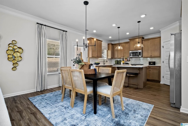 dining room with sink, dark hardwood / wood-style floors, and ornamental molding