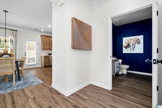 hall featuring a chandelier, dark hardwood / wood-style floors, and ornamental molding