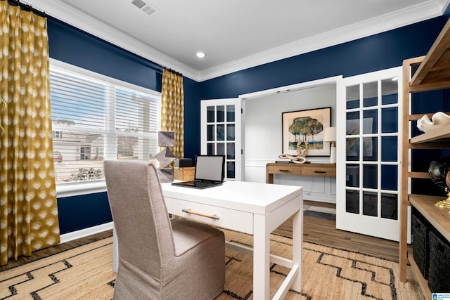 office space with plenty of natural light, wood-type flooring, ornamental molding, and french doors