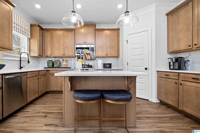 kitchen featuring stainless steel appliances, decorative backsplash, and decorative light fixtures