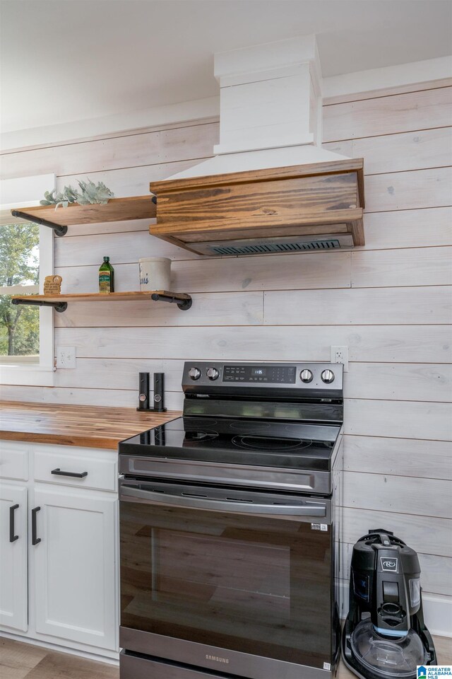 21023 Monroe Dunn Rd, Berry, AL 35546 - kitchen with wooden counters, custom range hood, wooden walls, white cabinets, and stainless steel electric stove