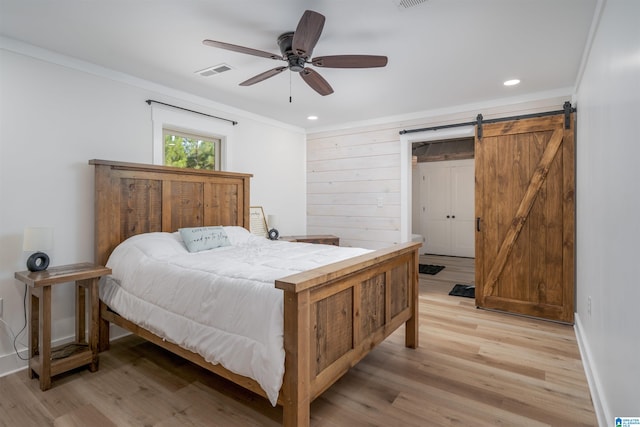21023 Monroe Dunn Rd, Berry, AL 35546 - bedroom featuring ornamental molding, light wood-type flooring, a barn door, and ceiling fan