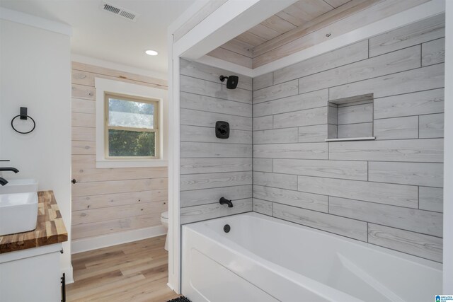 21023 Monroe Dunn Rd, Berry, AL 35546 - full bathroom featuring tiled shower / bath, wood-type flooring, vanity, wooden walls, and toilet