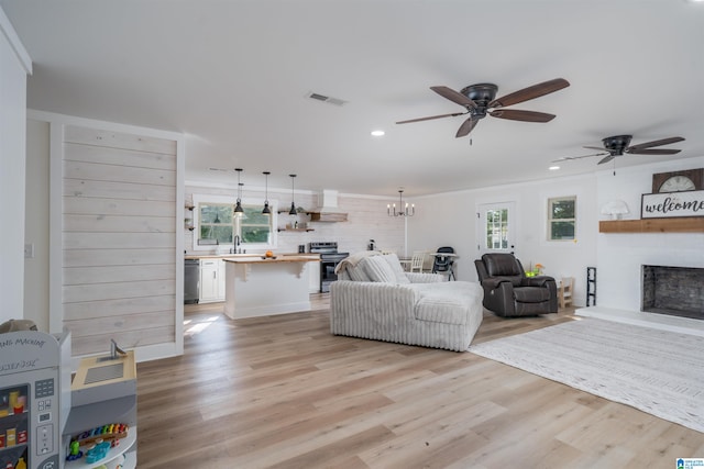 21023 Monroe Dunn Rd, Berry, AL 35546 - living room with ornamental molding, ceiling fan with notable chandelier, light hardwood / wood-style flooring, and sink