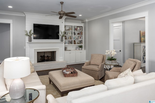 living room with ceiling fan, crown molding, and a fireplace