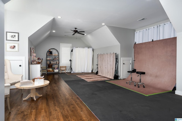 exercise area featuring dark hardwood / wood-style flooring, vaulted ceiling, and ceiling fan