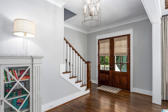 foyer with french doors, a chandelier, dark hardwood / wood-style floors, and ornamental molding