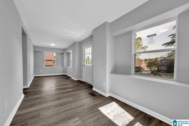 interior space featuring baseboards, visible vents, and wood finished floors
