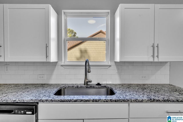 kitchen with white cabinets, dishwasher, decorative backsplash, and a sink