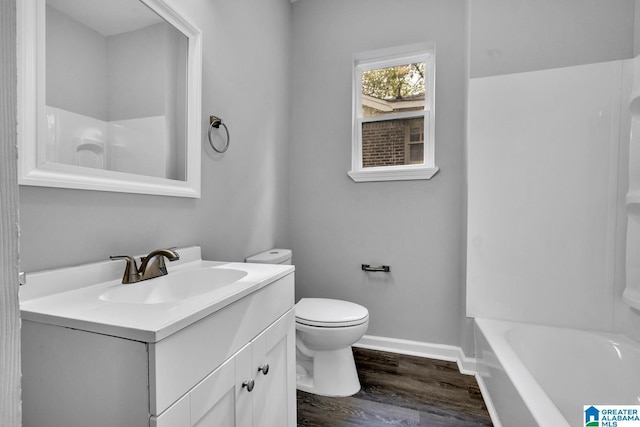 full bath featuring toilet, wood finished floors, vanity, and baseboards