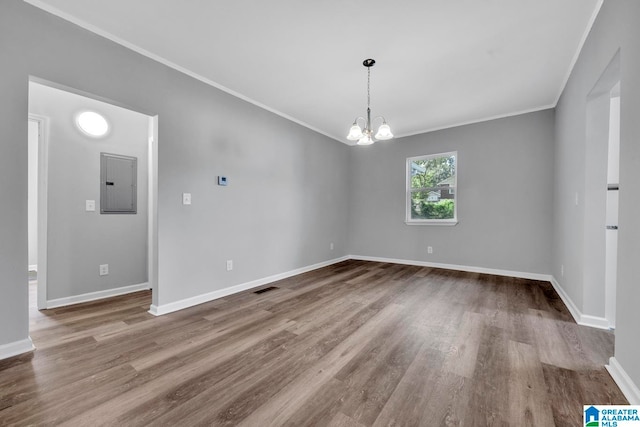 unfurnished room featuring ornamental molding, electric panel, and hardwood / wood-style floors