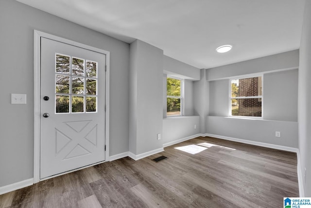 foyer entrance with wood finished floors, visible vents, and baseboards