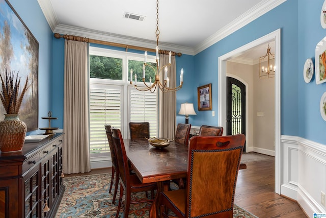 dining space featuring an inviting chandelier, plenty of natural light, ornamental molding, and dark hardwood / wood-style flooring