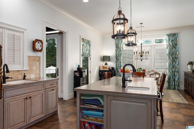 kitchen with a chandelier, a center island with sink, sink, and a wealth of natural light