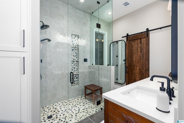 bathroom featuring tile patterned flooring, an enclosed shower, and vanity