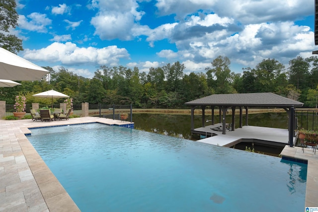 view of swimming pool featuring a dock, a water view, and a patio area