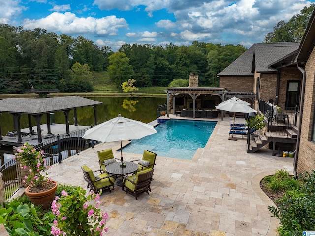 view of pool with a gazebo, a water view, and a patio area