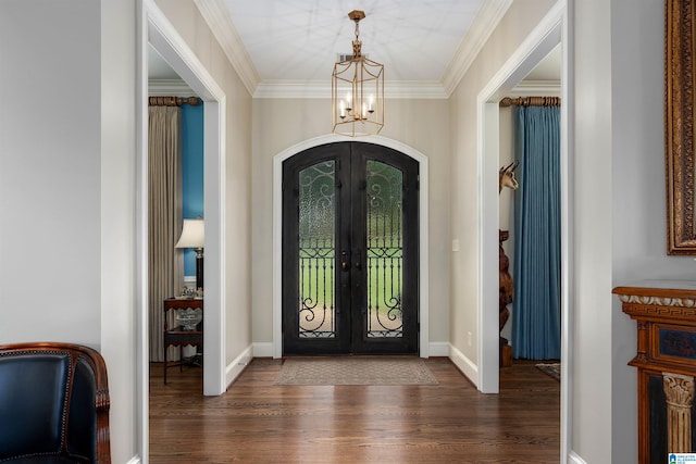 foyer featuring ornamental molding, a notable chandelier, french doors, and dark hardwood / wood-style flooring