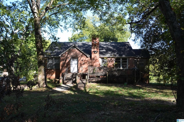 view of front facade with a deck and a front lawn