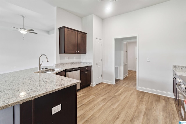 kitchen featuring light stone countertops, ceiling fan, stainless steel dishwasher, sink, and light hardwood / wood-style floors