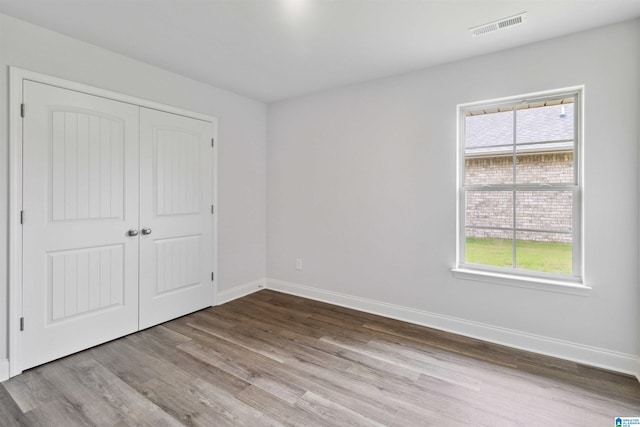 unfurnished bedroom with a closet and light hardwood / wood-style flooring