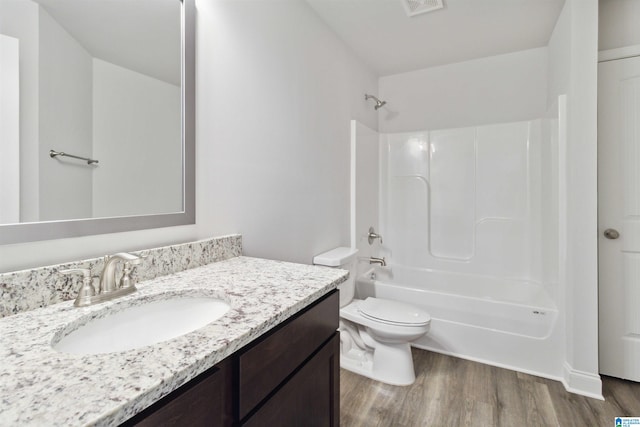 full bathroom with bathtub / shower combination, hardwood / wood-style flooring, vanity, and toilet