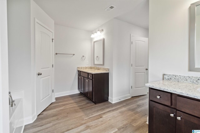 bathroom with a bathtub, hardwood / wood-style floors, and vanity