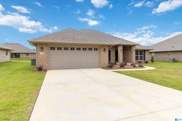 view of front of house with a front yard, a garage, and central AC unit