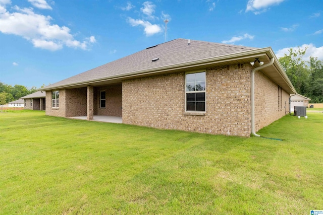 back of property featuring a yard, central AC, and a patio area