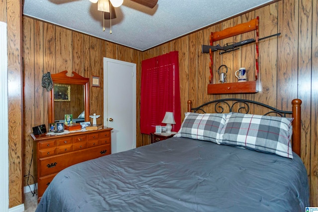 bedroom with ceiling fan and wood walls