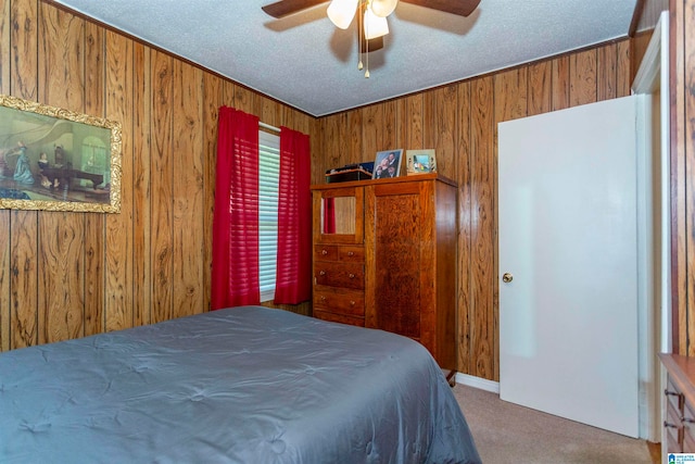 carpeted bedroom featuring wooden walls, ceiling fan, and a textured ceiling