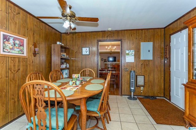 tiled dining room featuring ceiling fan with notable chandelier, electric panel, crown molding, and wood walls