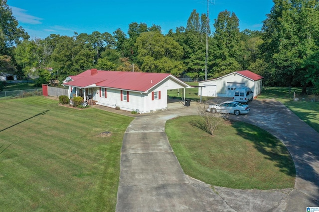 view of front of property featuring a front lawn, a carport, a garage, and an outdoor structure