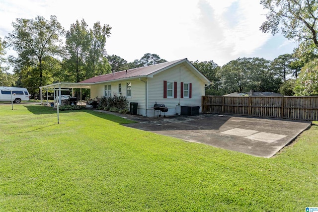 view of side of property featuring a carport, central air condition unit, and a yard