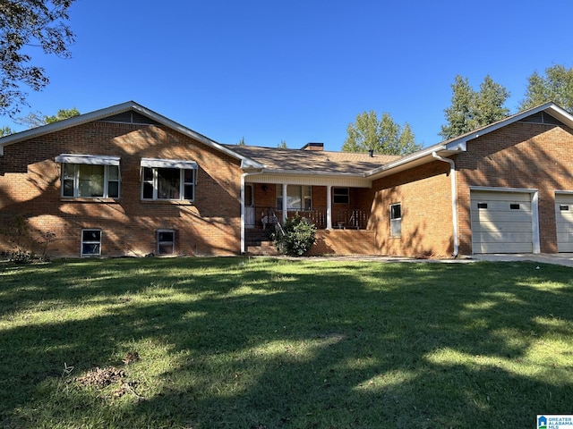 view of front of home featuring a garage, a porch, and a front lawn