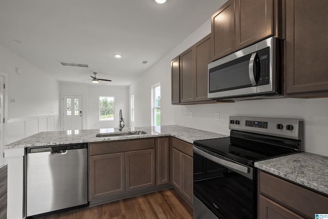 kitchen featuring ceiling fan, sink, kitchen peninsula, stainless steel appliances, and dark hardwood / wood-style floors