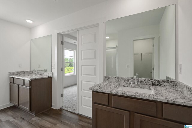 bathroom featuring hardwood / wood-style flooring, an enclosed shower, and vanity