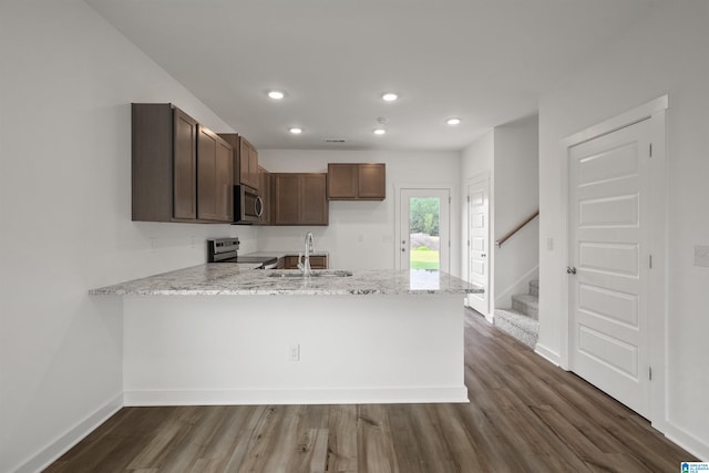 kitchen featuring dark hardwood / wood-style flooring, stainless steel appliances, sink, and kitchen peninsula