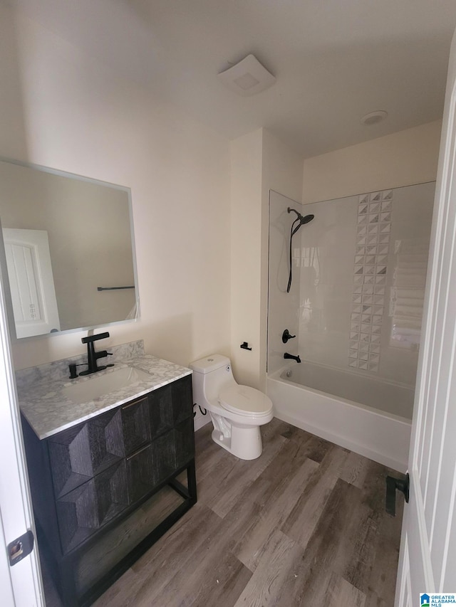 full bathroom with tub / shower combination, hardwood / wood-style floors, toilet, and vanity