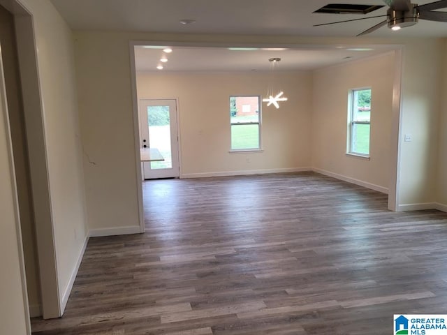 unfurnished room with ceiling fan with notable chandelier and dark hardwood / wood-style floors