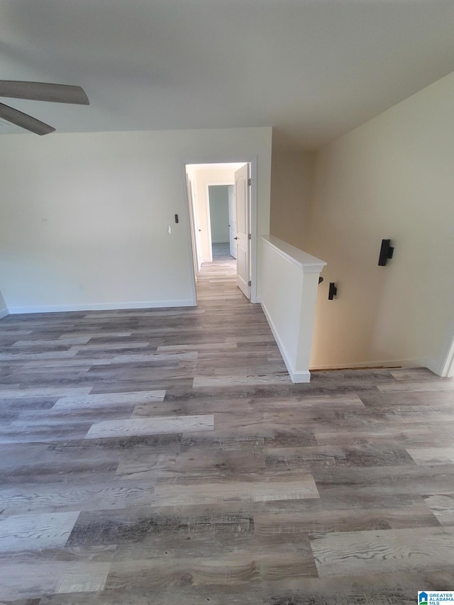 empty room with ceiling fan and hardwood / wood-style flooring