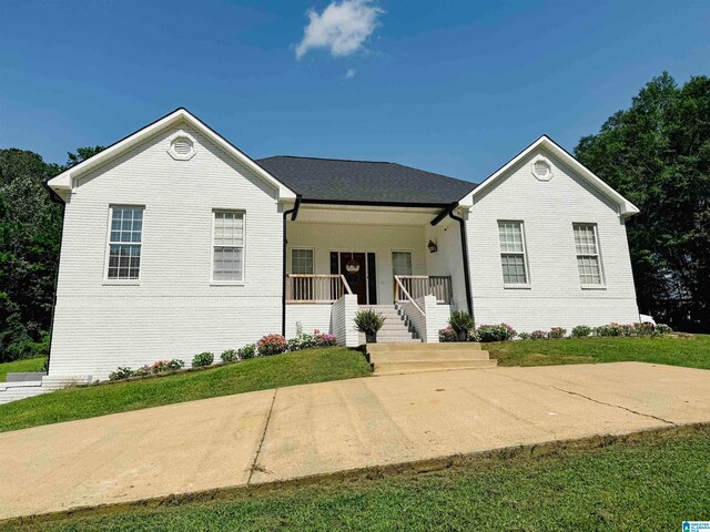 ranch-style house with a front lawn and covered porch